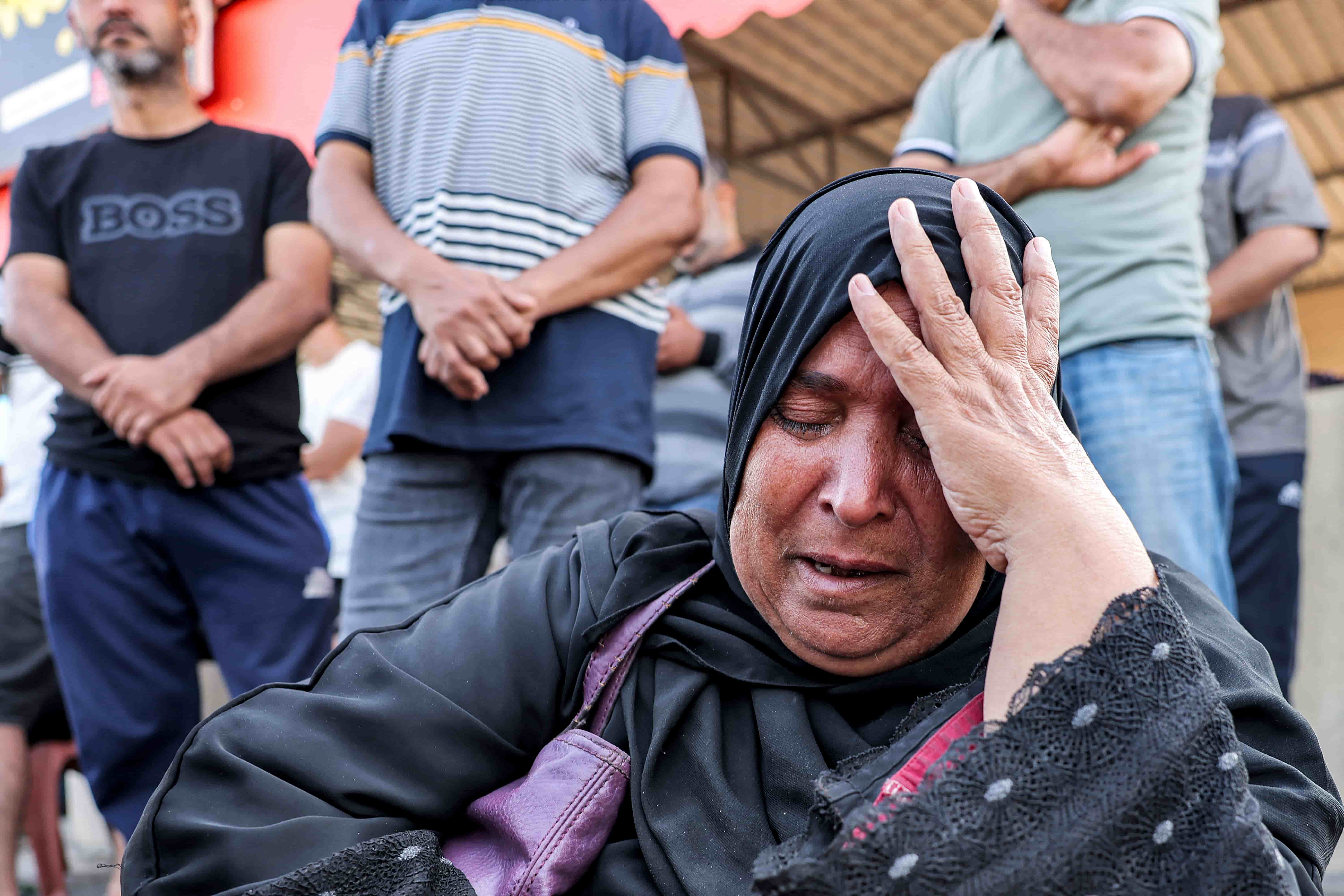 Sabah Said, a Palestinian-Egyptian dual national, cries as she waits at the crossing. [Mohammed Abed/AFP]
