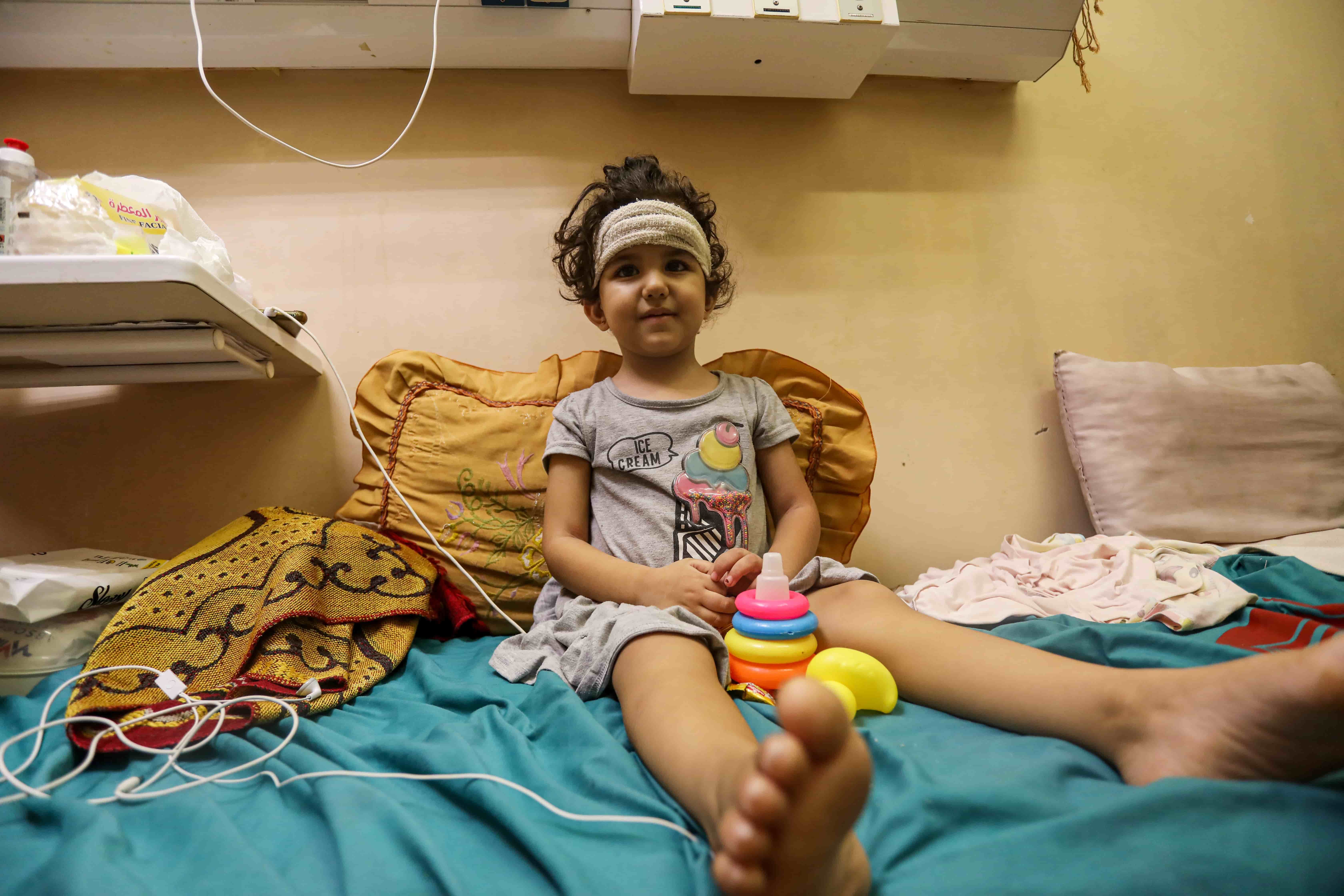 Jude al-Sharif spent a day in a coma after she was wounded by shrapnel that hit her head. Israeli warplanes had targeted the car next to her family while they were attempting to flee south in the Gaza Strip. [Abdelhakim Abu Riash/Al Jazeera]