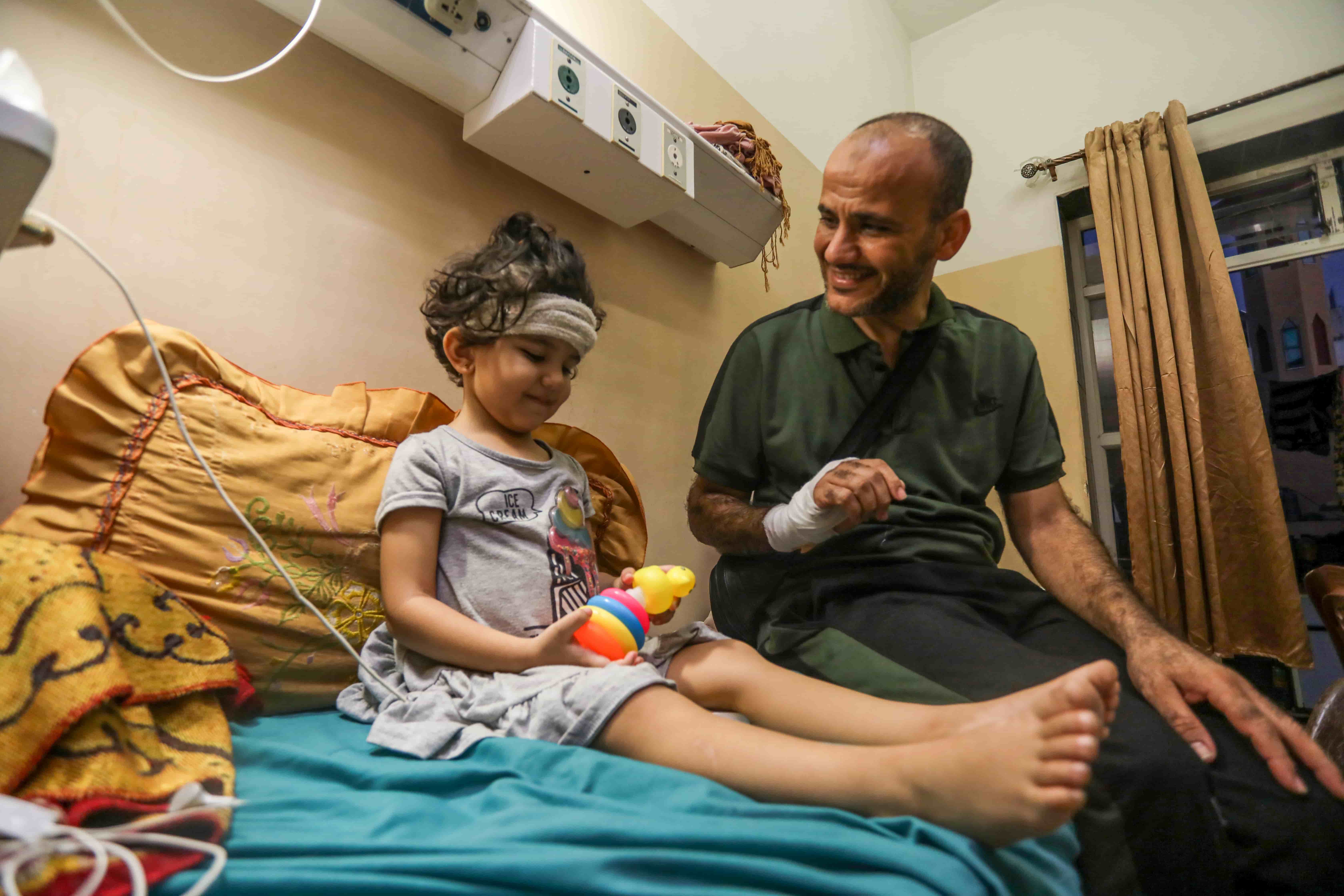 Jude's father Taiseer said he her condition has improved a lot, and with the toys he buys her she has begun interacting with people and speaking a bit again. [Abdelhakim Abu Riash/Al Jazeera]